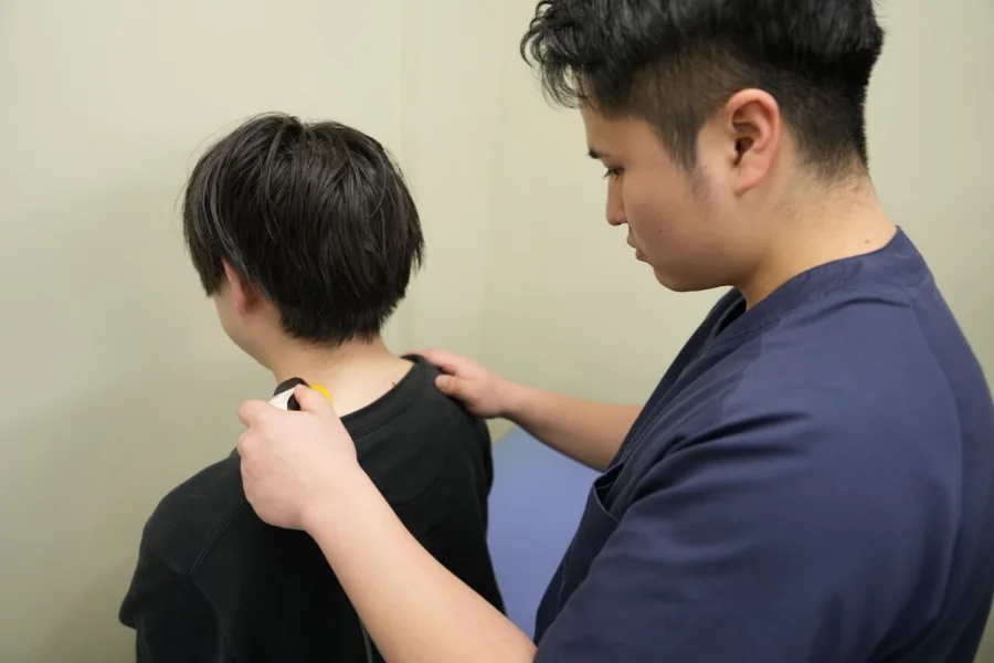肩の痛みの状態を確認する柔道整復師